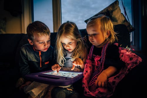 Free Three Children Looking at a Tablet Computer Stock Photo
