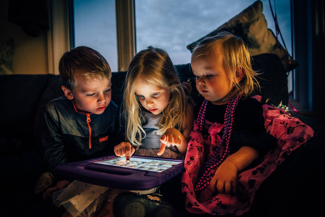 gratis Drie Kinderen Kijken Naar Een Tabletcomputer Stockfoto