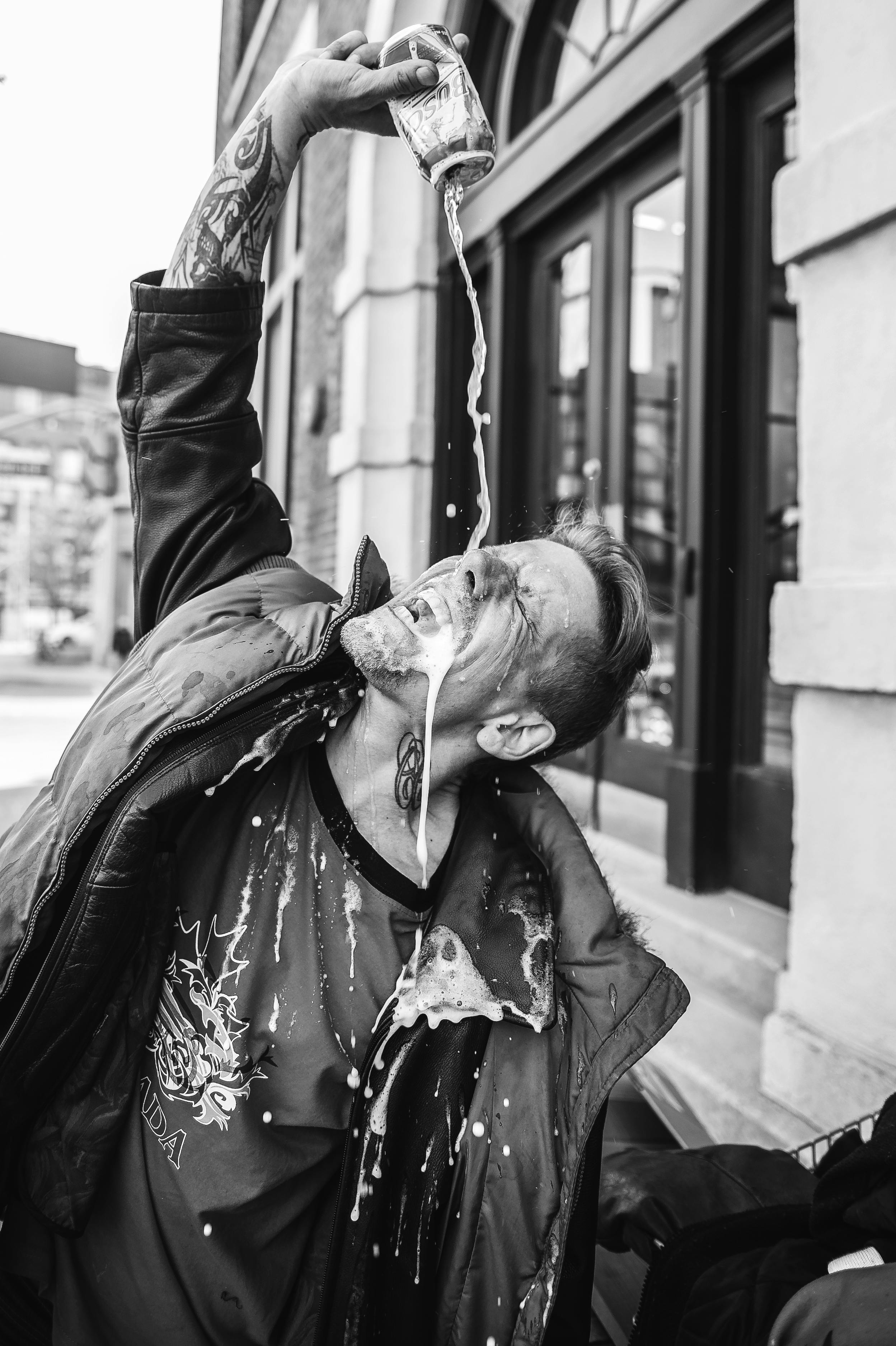 Man pouring beer from a can on his face. | Photo: Pexels