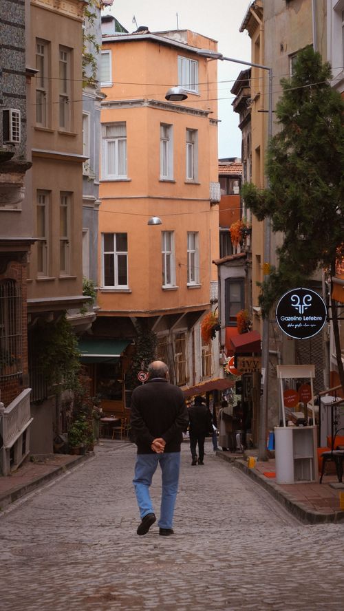 Free Beautiful street scene in a historic Istanbul neighborhood with a cobblestone pathway and colorful buildings. Stock Photo