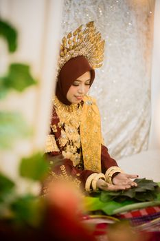A bride in traditional Indonesian attire sits elegantly, showcasing cultural heritage. - Fotografer Sidoarjo