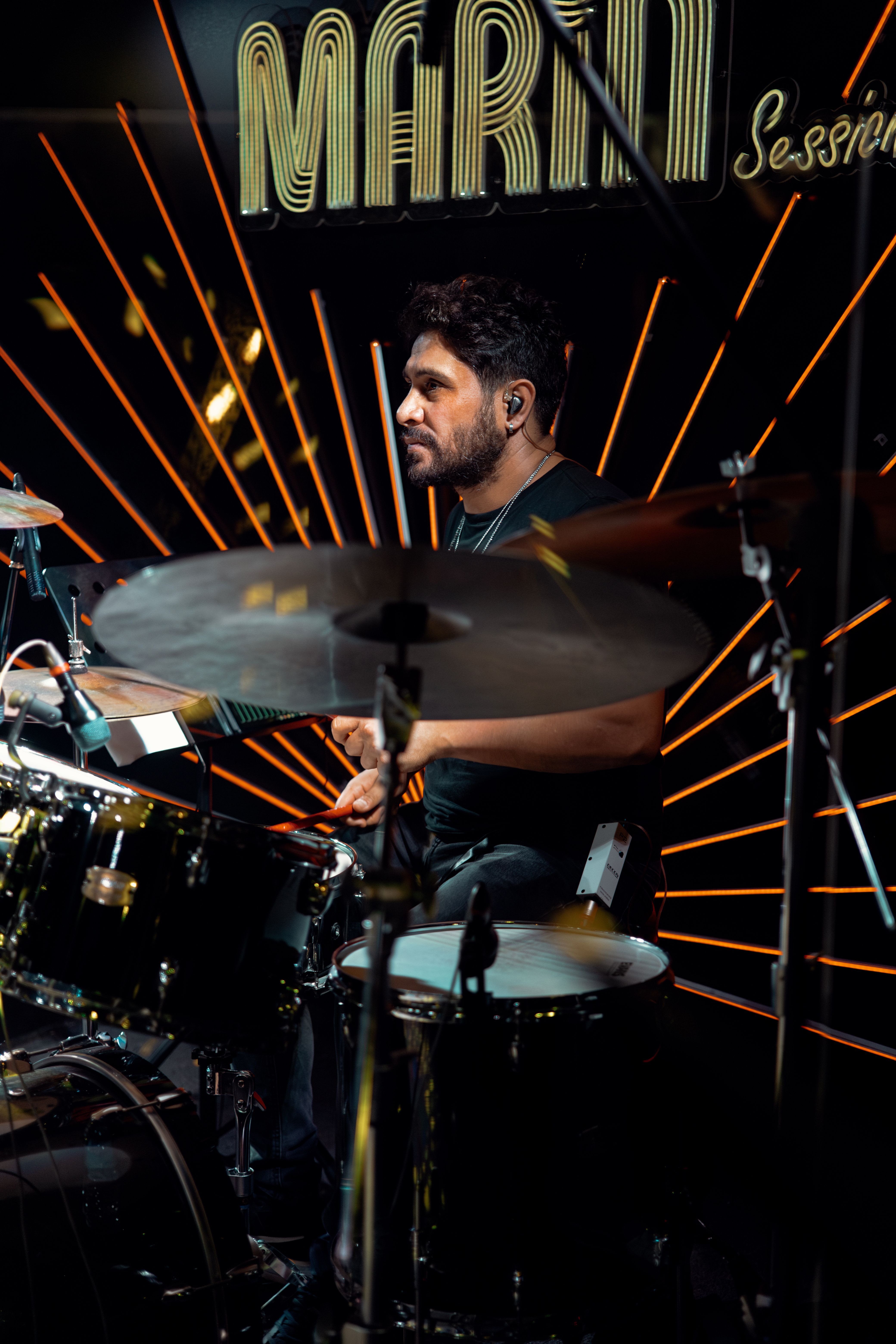 Captivating live performance of a drummer under stage lighting during a musical session.