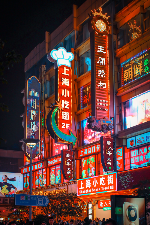 Free Colorful neon signage lights up the bustling Shanghai Snack Street at night, capturing urban vibrance. Stock Photo