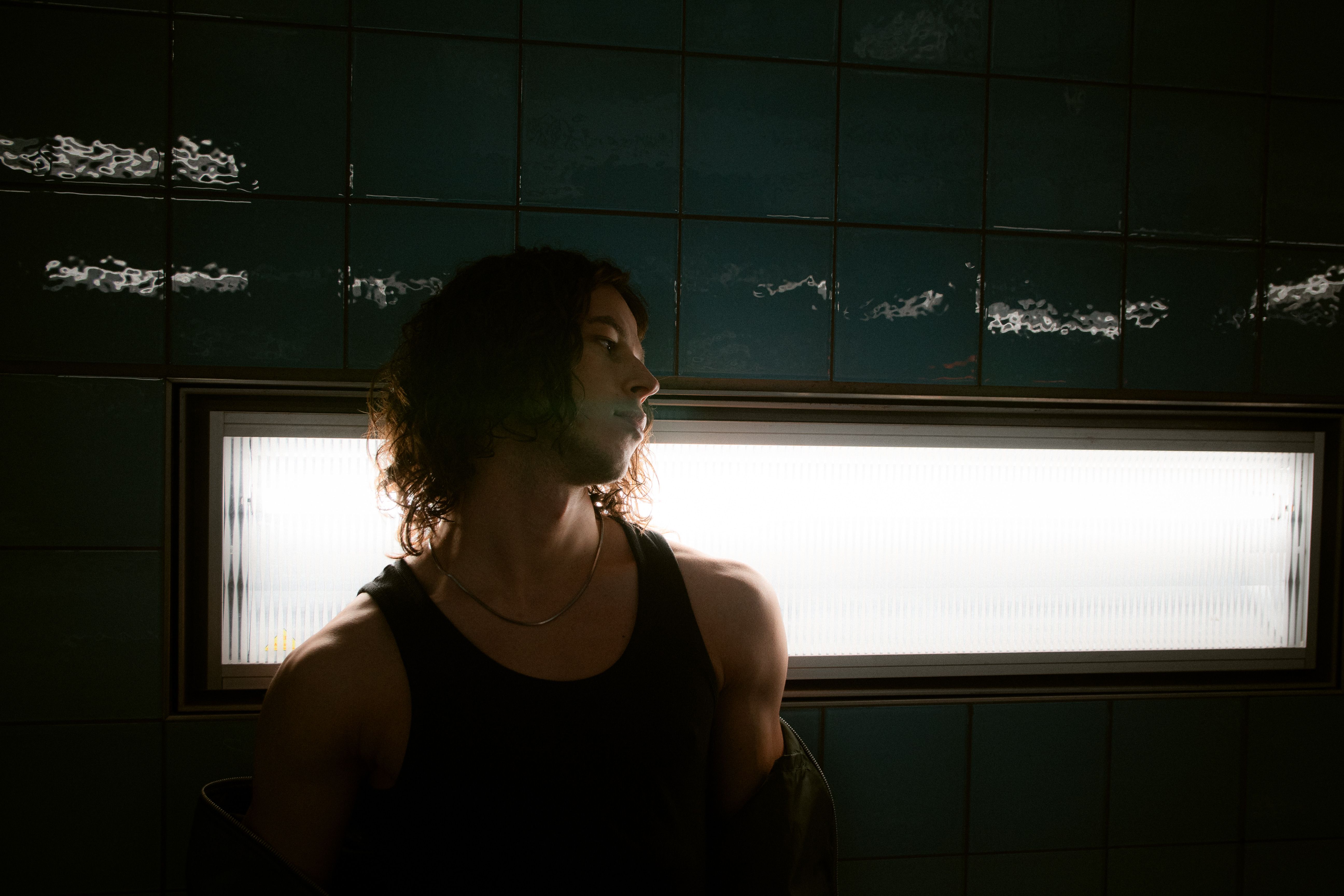 A moody portrait of a person in a dimly lit Hamburg subway station.