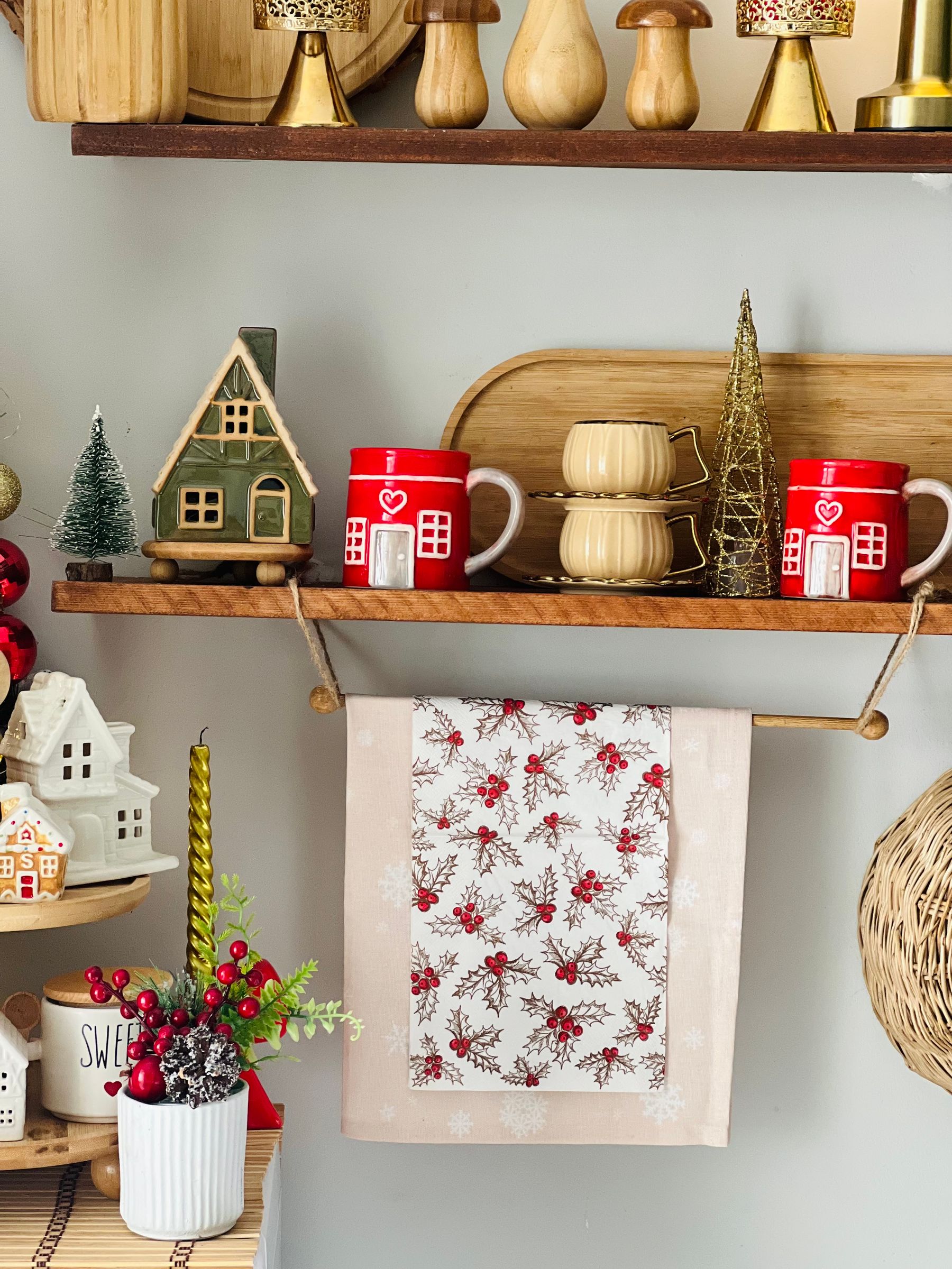 Festive kitchen shelf with red mugs miniature houses and Christmas decorations