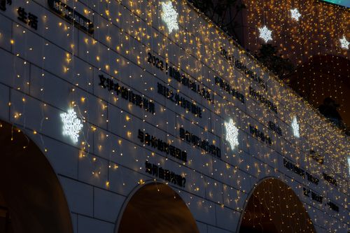 Free Building decorated with snowflake lights and strings of yellow fairy lights. Stock Photo