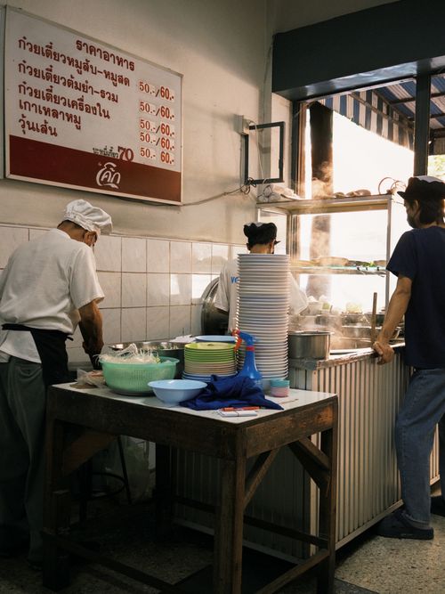 Free Street food vendors preparing meals in an Asian food stall. Stock Photo