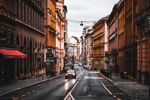 Quiet city street in Budapest with historical architecture and a lone car, showcasing urban charm.