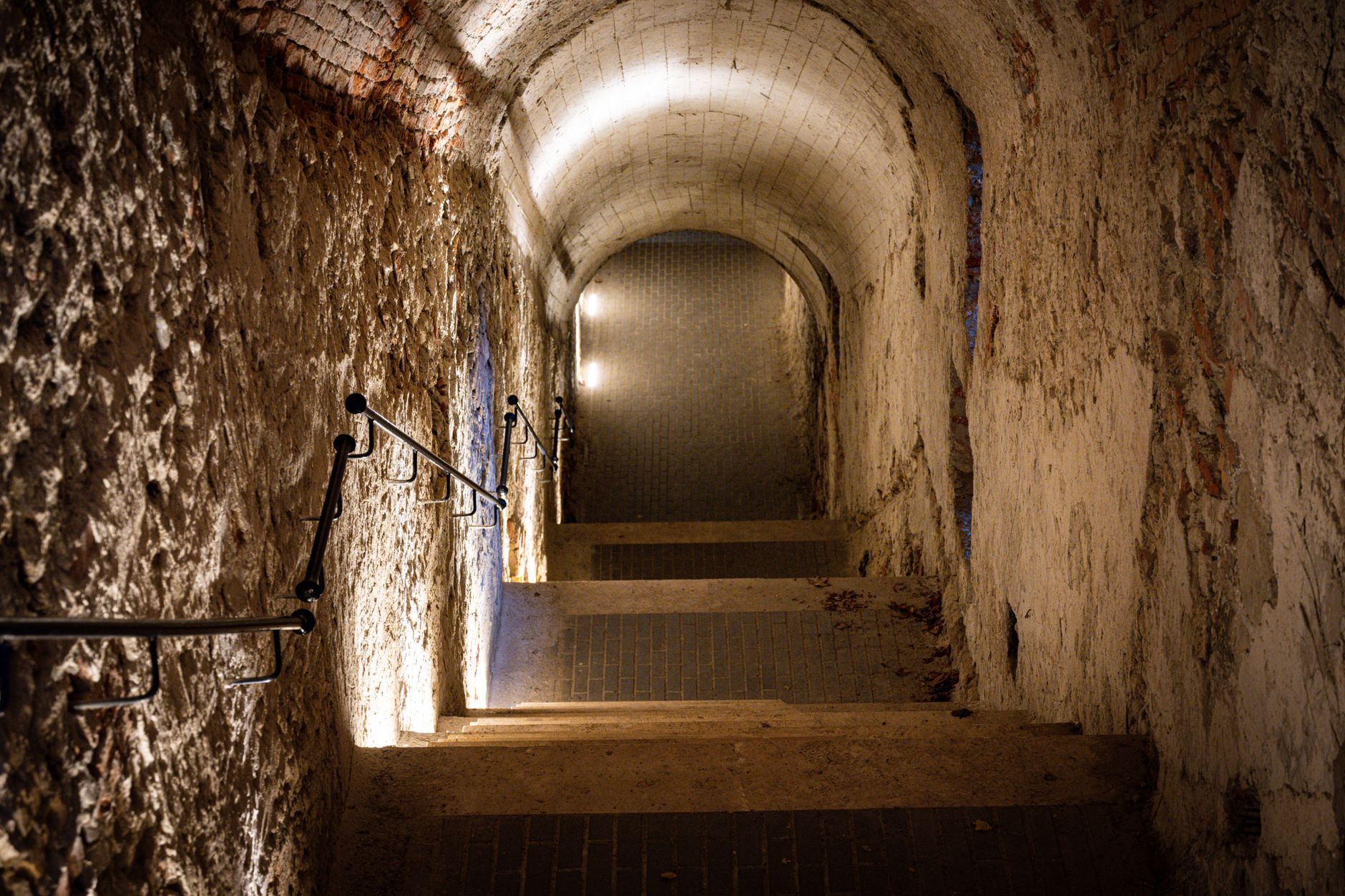 Explore a dimly lit stone staircase in Budapest's underground tunnel.