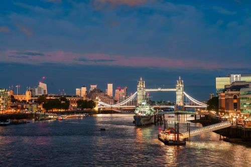 Free Stunning night view of Tower Bridge illuminated over the River Thames in London, showcasing the city's skyline. Stock Photo