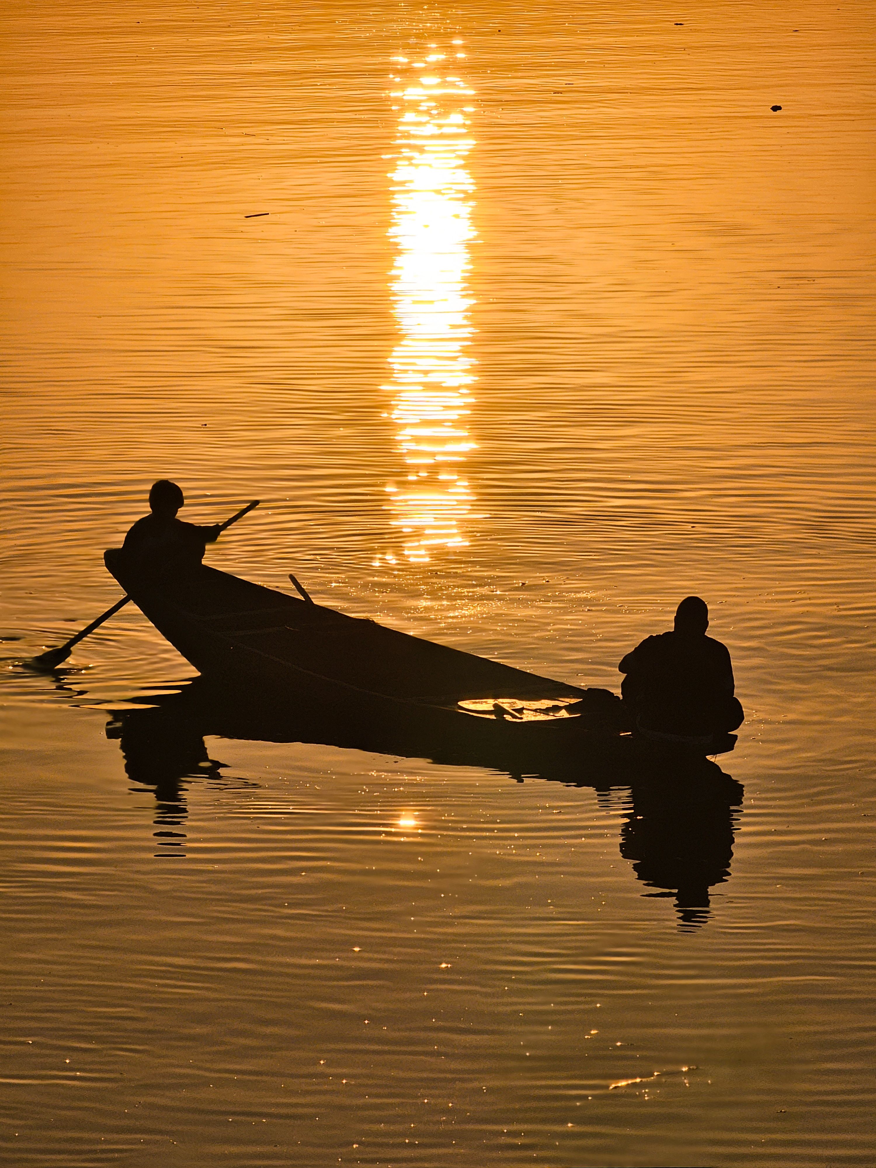 Silhouetted Boat Ride at Sunset on Golden Waters · Free Stock Photo