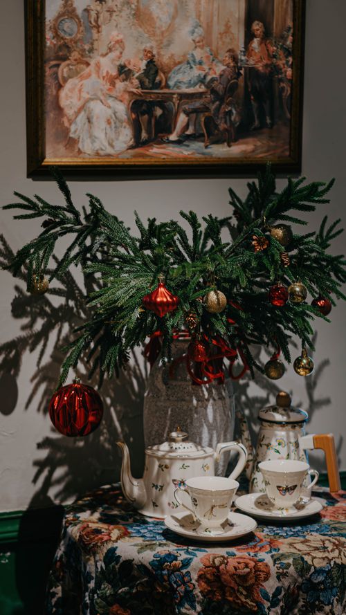 Free Vintage-style Christmas tea setup featuring a festive teapot, cups, and decorations. Stock Photo