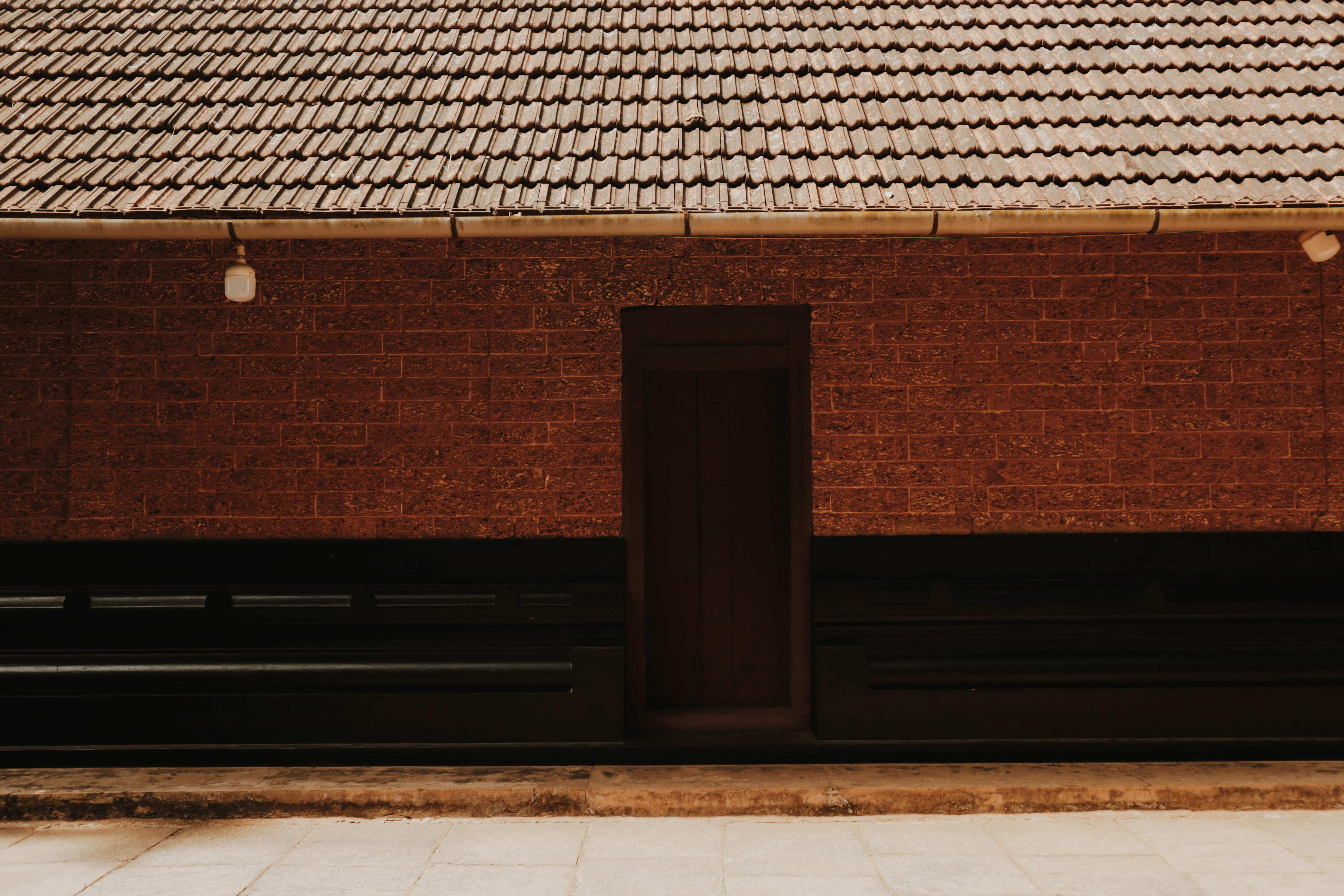 Miễn phí Mặt tiền bằng gạch mộc mạc với cửa gỗ và mái ngói. Ảnh lưu trữ