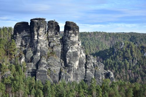 Free View of the majestic rocky cliffs surrounded by dense forest in Saxon Switzerland National Park. Stock Photo