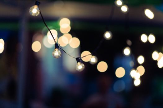 Close-up of string lights creating a dreamy bokeh effect at night, perfect for festive occasions.