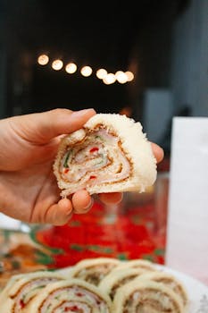Close-up of a hand holding an Argentine sandwich roll, perfect for festive gatherings.