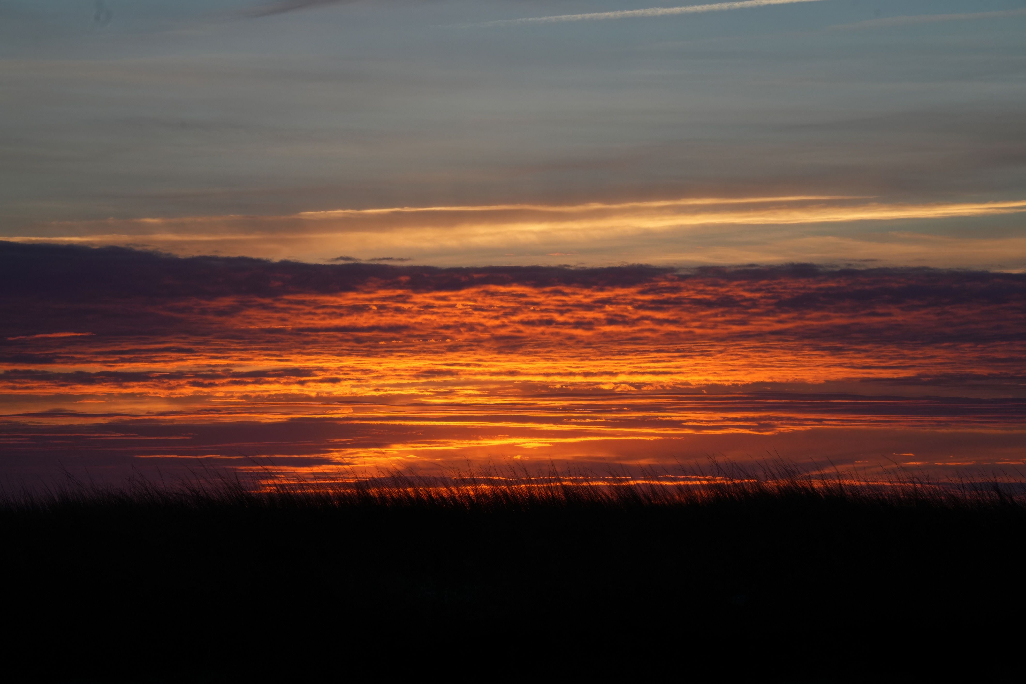 Stunning Vibrant Sunset over Dark Landscape · Free Stock Photo
