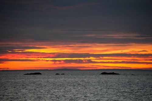 Free Breathtaking view of a vibrant sunset over the ocean with dramatic clouds. Stock Photo