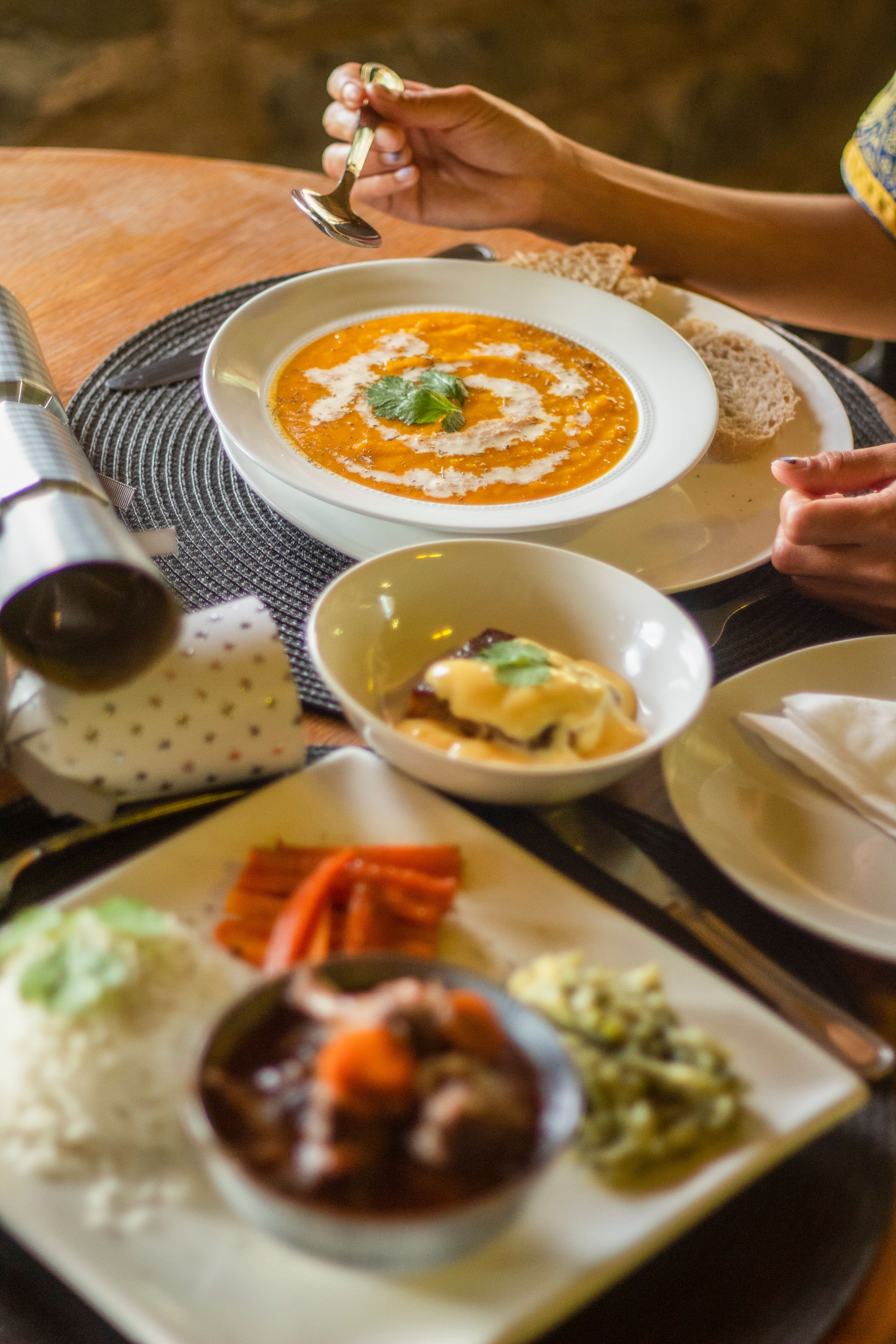 A homely Indian meal with curry, rice, and side dishes on a wooden table, perfect for food lovers.