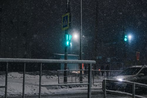 Free A snowy night in the city with glowing traffic lights and falling snow creating a serene urban landscape. Stock Photo