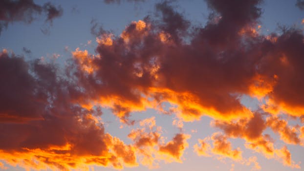 Breathtaking view of vibrant orange clouds during sunset, capturing the magical transition of daylight.