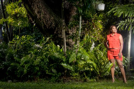 Woman in vibrant attire poses confidently in a lush tropical garden in Puerto Plata.