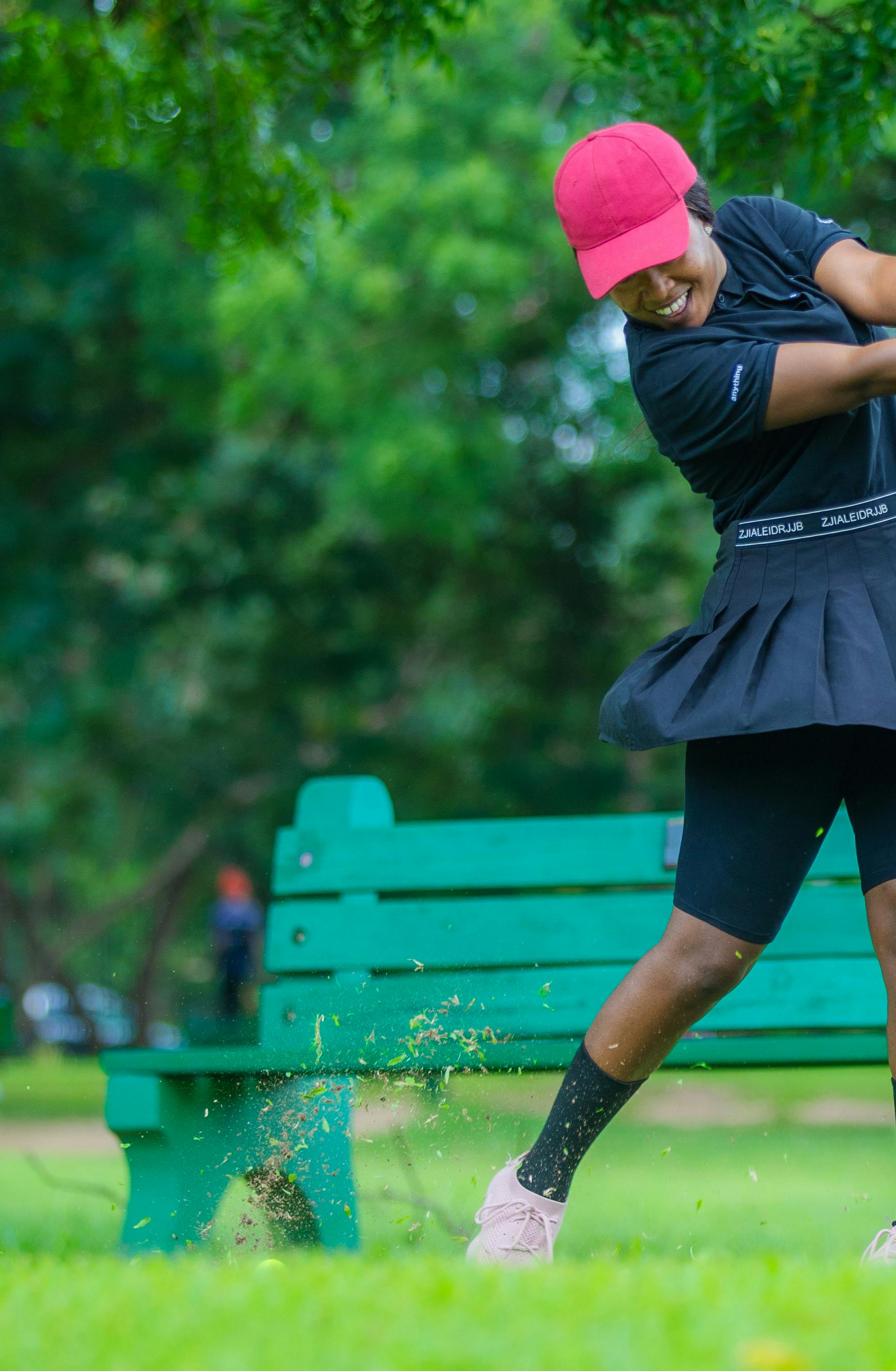 Dynamic photo of a young golfer swinging in a lush park setting. Perfect for sports imagery.