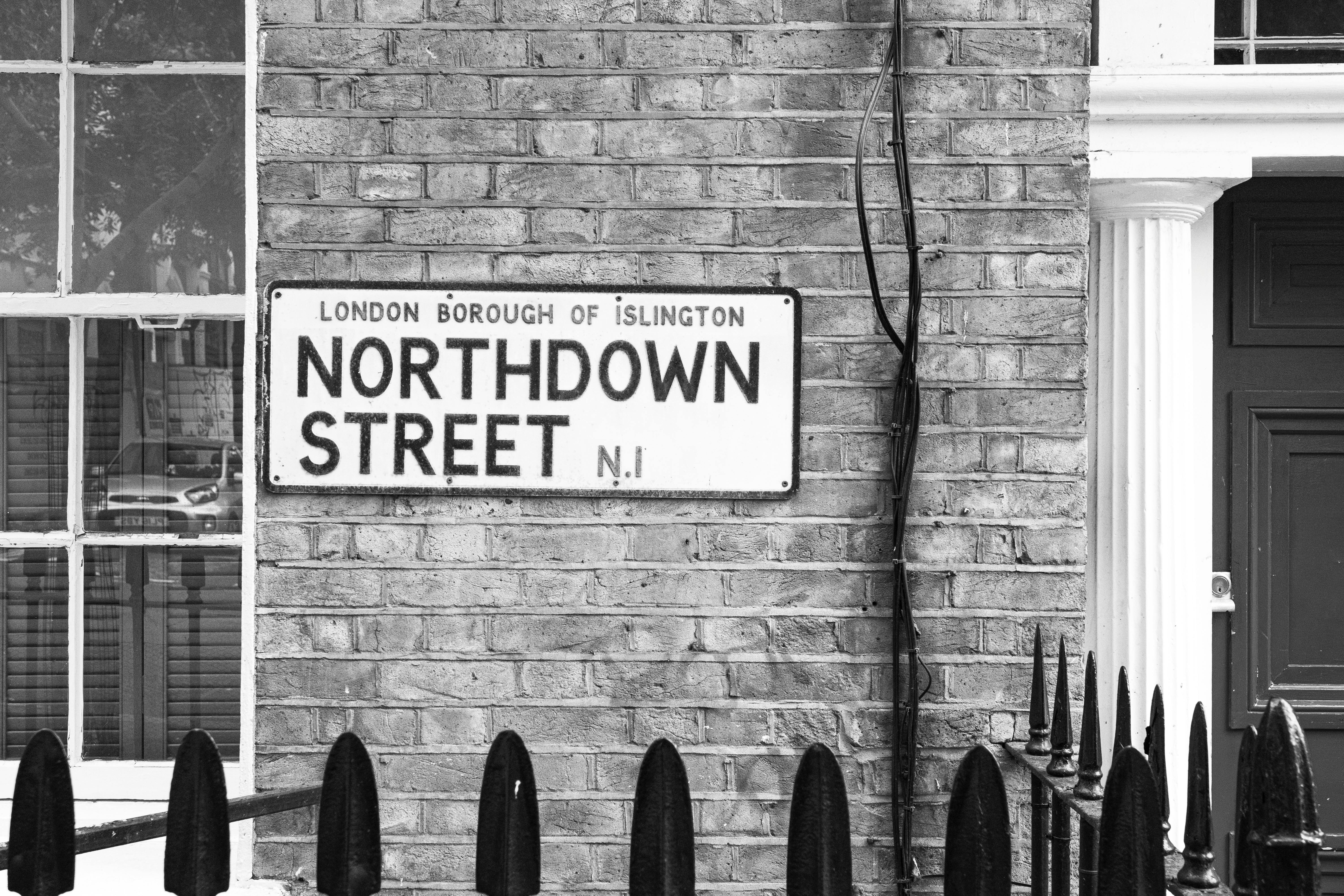 Monochrome photo of Northdown Street sign in Islington, London. Urban architecture with classic brick facade.