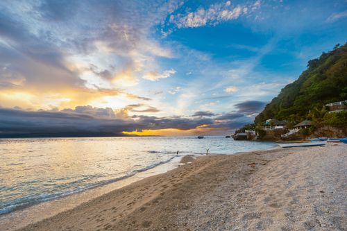 Free Stunning beach scene at sunset with vibrant skies and calm waters, perfect for travel inspiration. Stock Photo