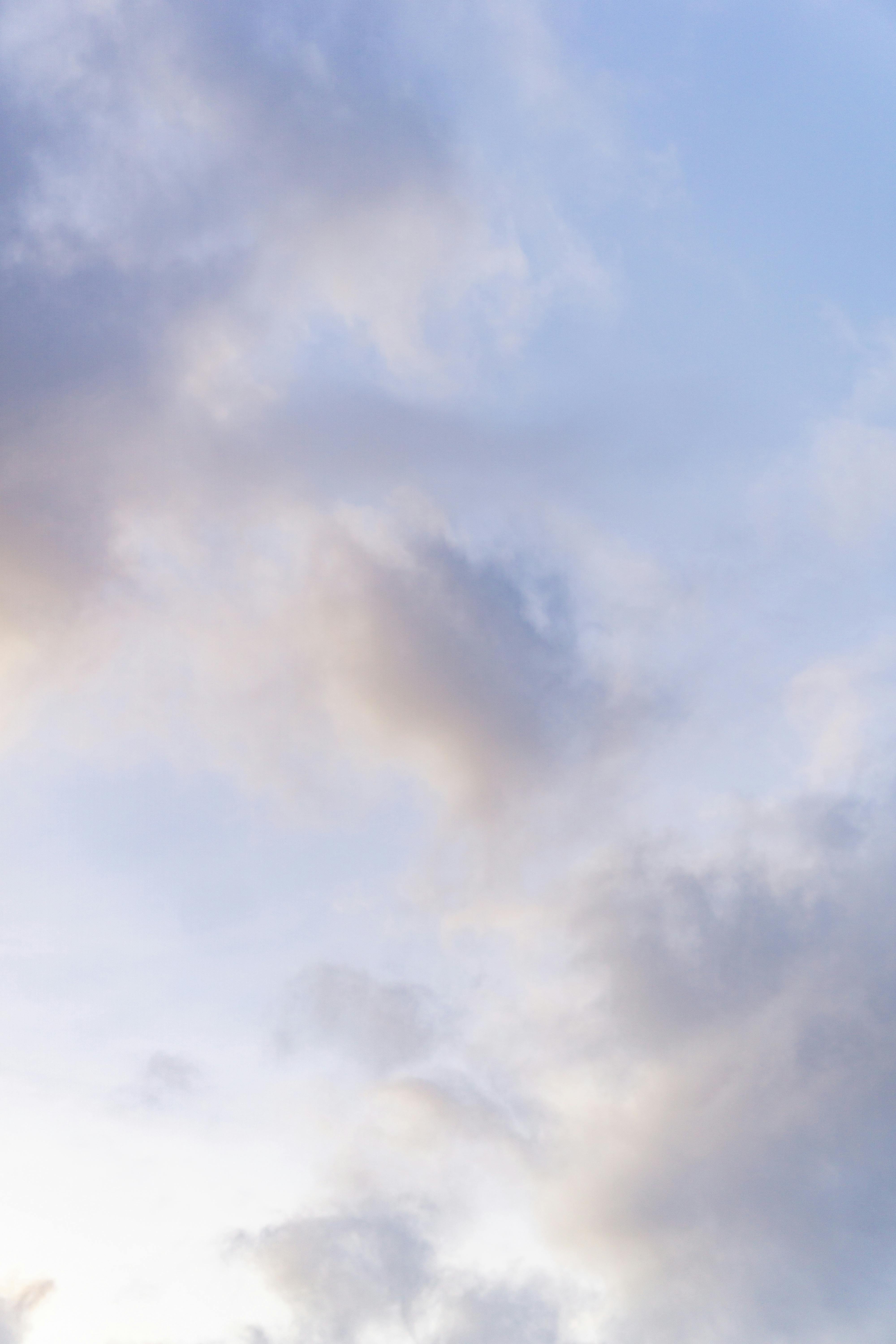 Безкоштовне Безтурботний вид м'яких пастельних хмар на тлі чистого блакитного неба, що створює мирну та заспокійливу сцену. стокове фото