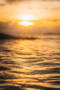 A stunning view of the sun setting over ocean waves with golden reflections creating a serene atmosphere.