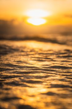 A serene sunset over the ocean with golden reflections on the water surface.