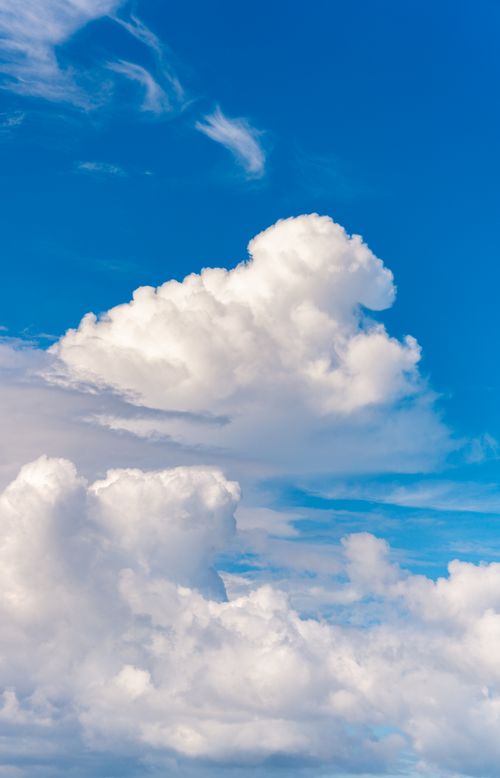 Free Fluffy cumulus clouds against a clear blue daytime sky, depicting peacefulness and nature's beauty. Stock Photo