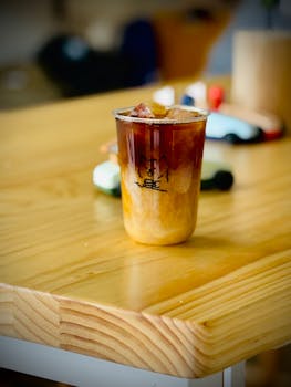 A refreshing iced coffee placed on a wooden table indoors, perfect for a cozy cafe atmosphere.