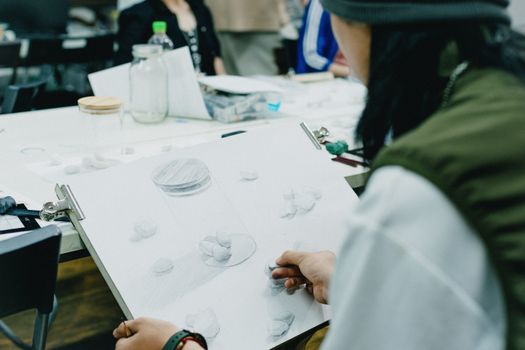 Students sketching a still life arrangement in a Tokyo art class, capturing creative still life moments.