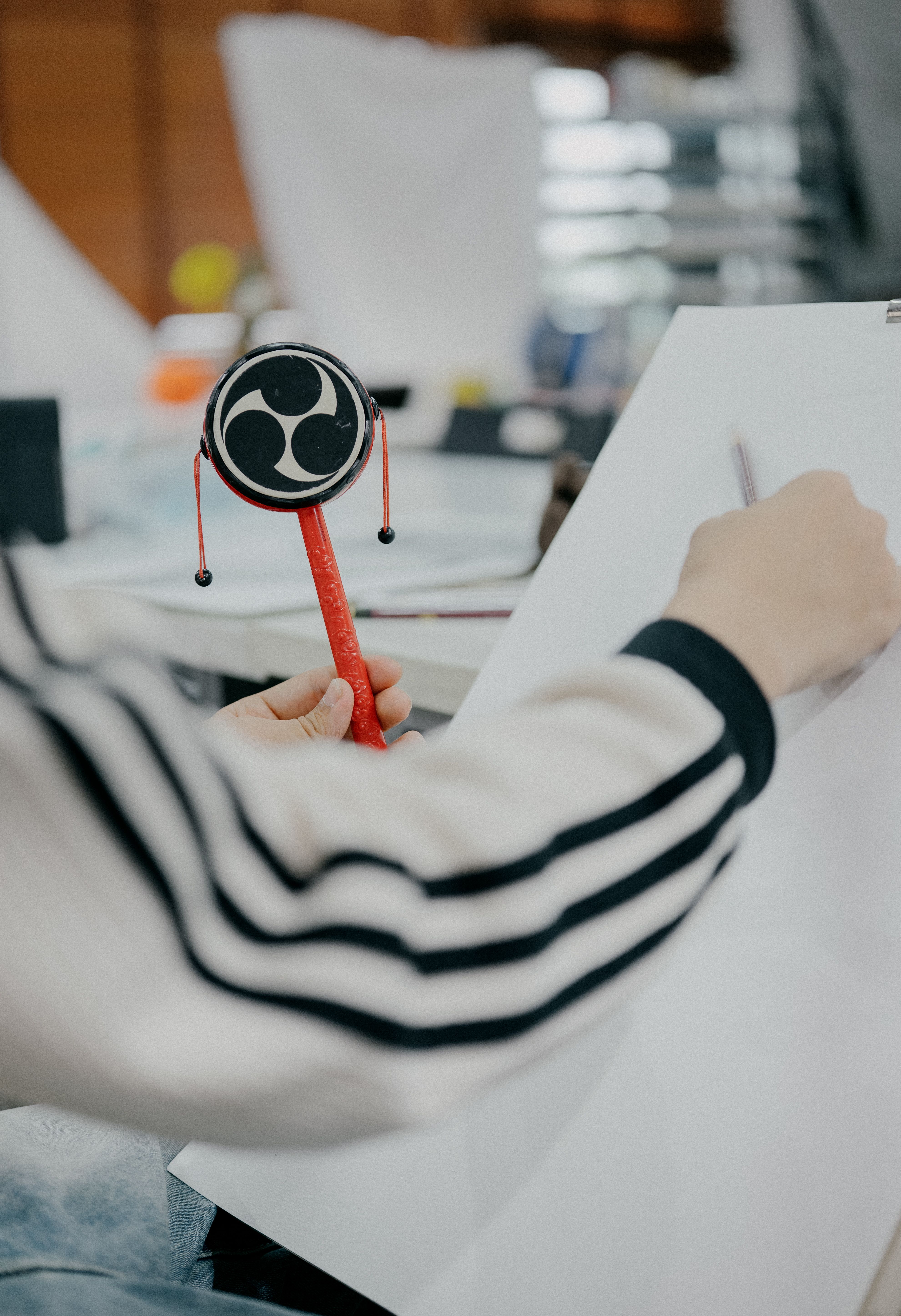 A person sketching with traditional Japanese art instruments, emphasizing creativity.