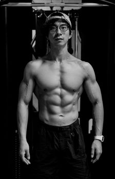 Fit young man in Tokyo gym showing off well-defined muscles and strong physique.