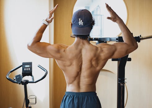 Back view of a muscular man lifting weights in a contemporary gym.