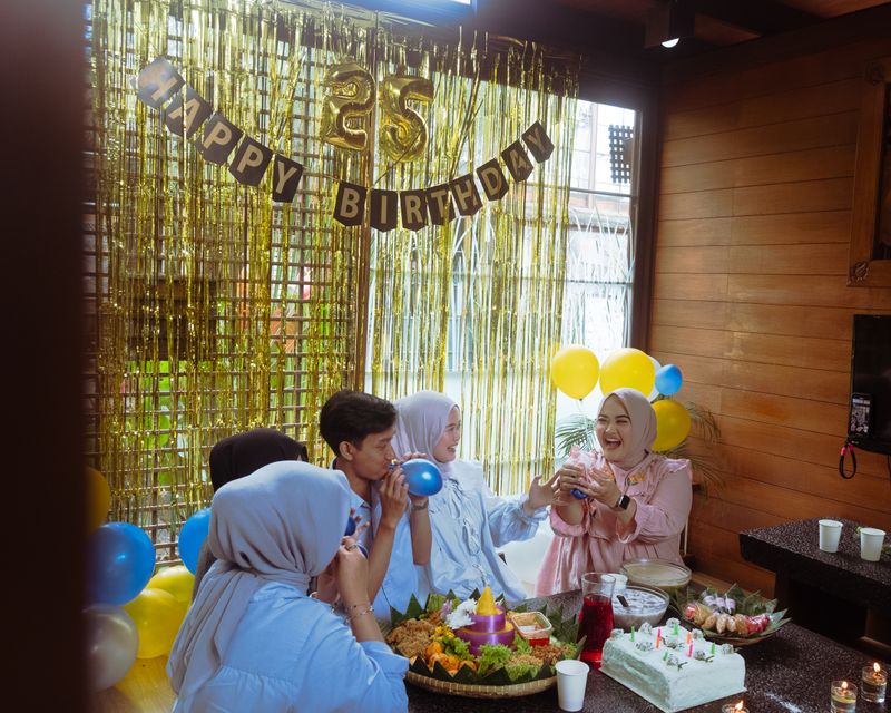 Joyful 25th birthday celebration with balloons and cake