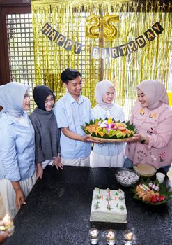 Family celebrating a 25th birthday with festive cake and decorations indoors. - Fotografer Sidoarjo