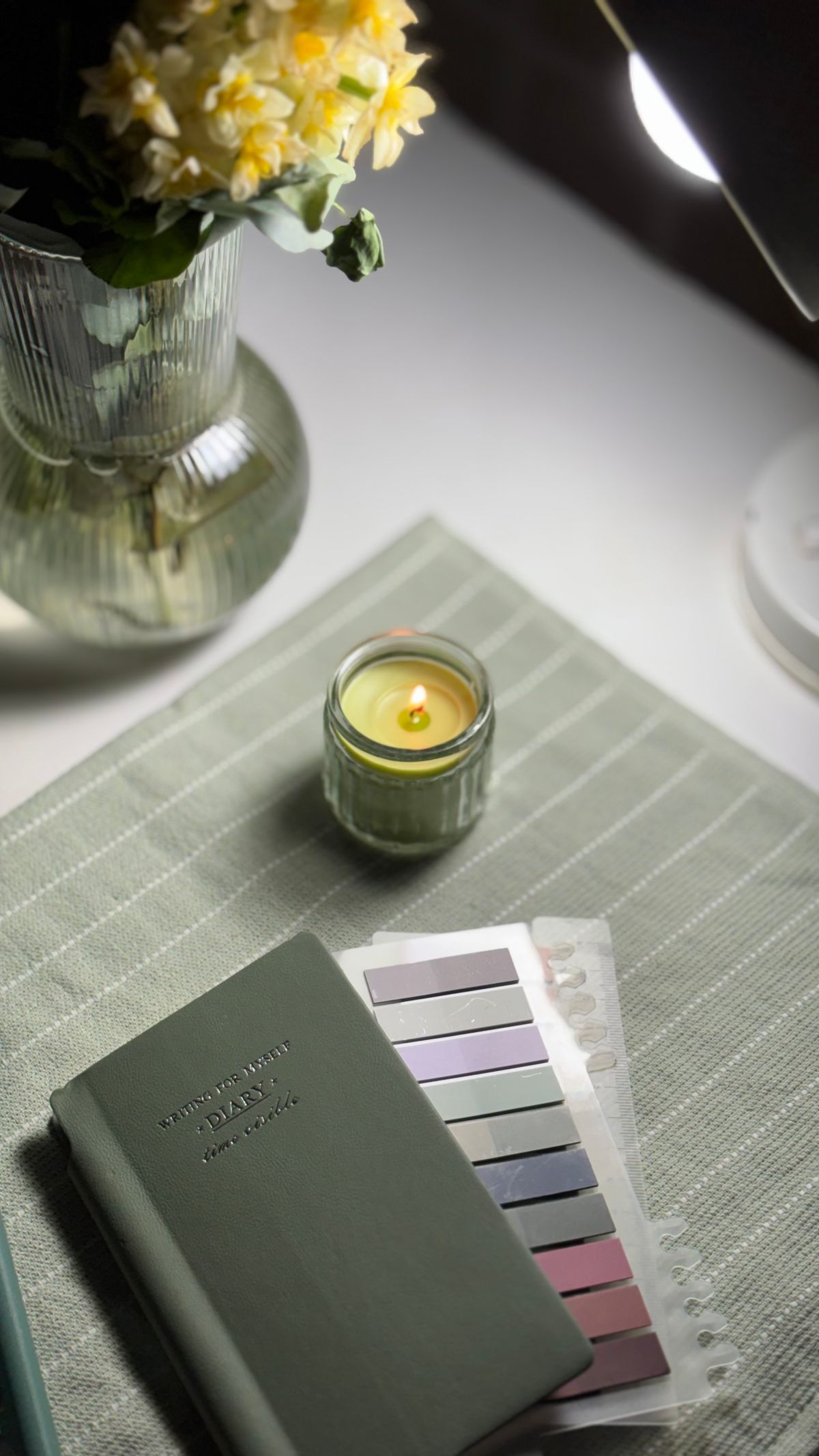 Escritorio cálido con velas y diario abierto