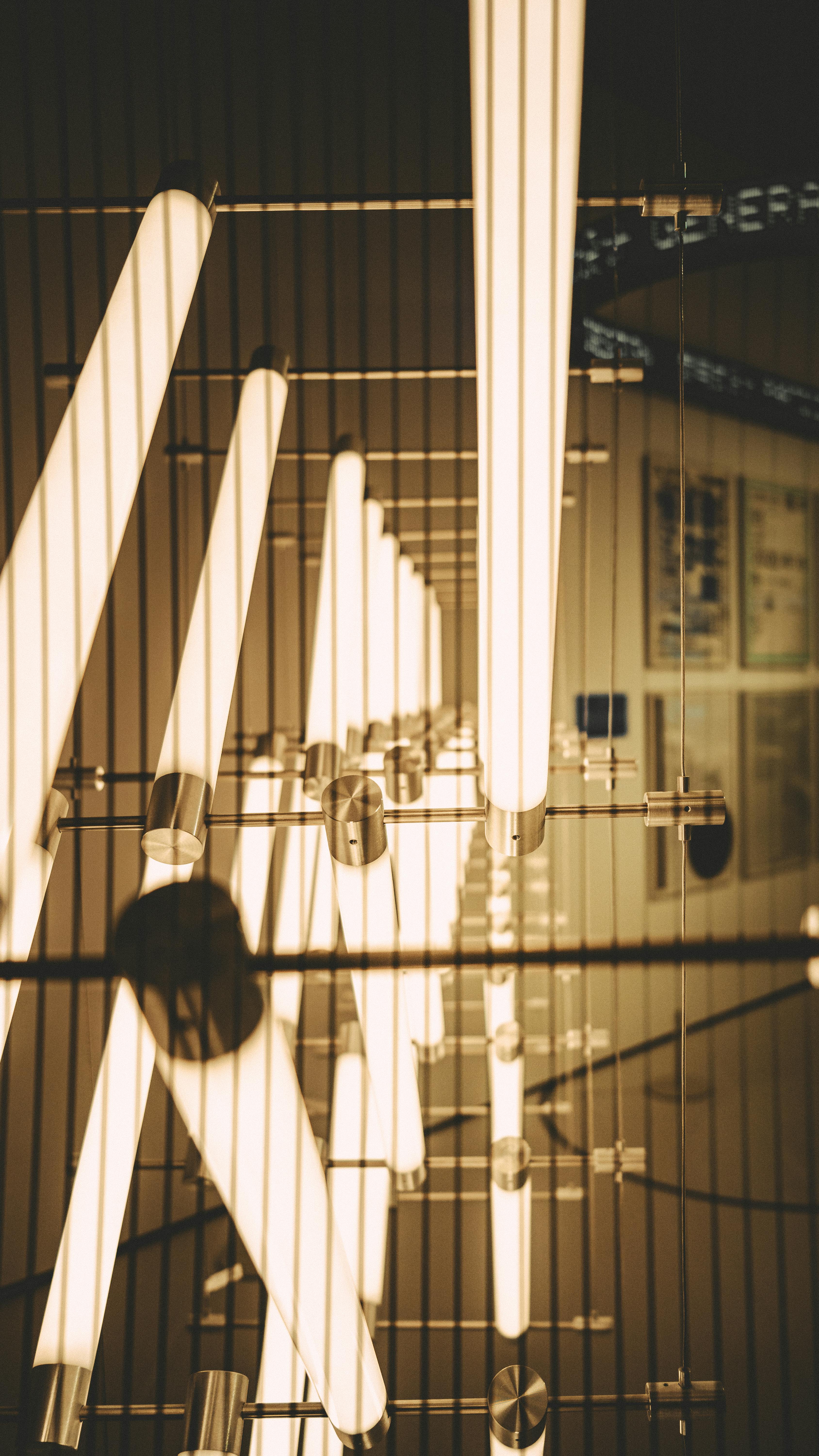 grátis Uma instalação moderna com tubos de luz verticais que cria uma estética abstrata em um ambiente interno. Foto profissional