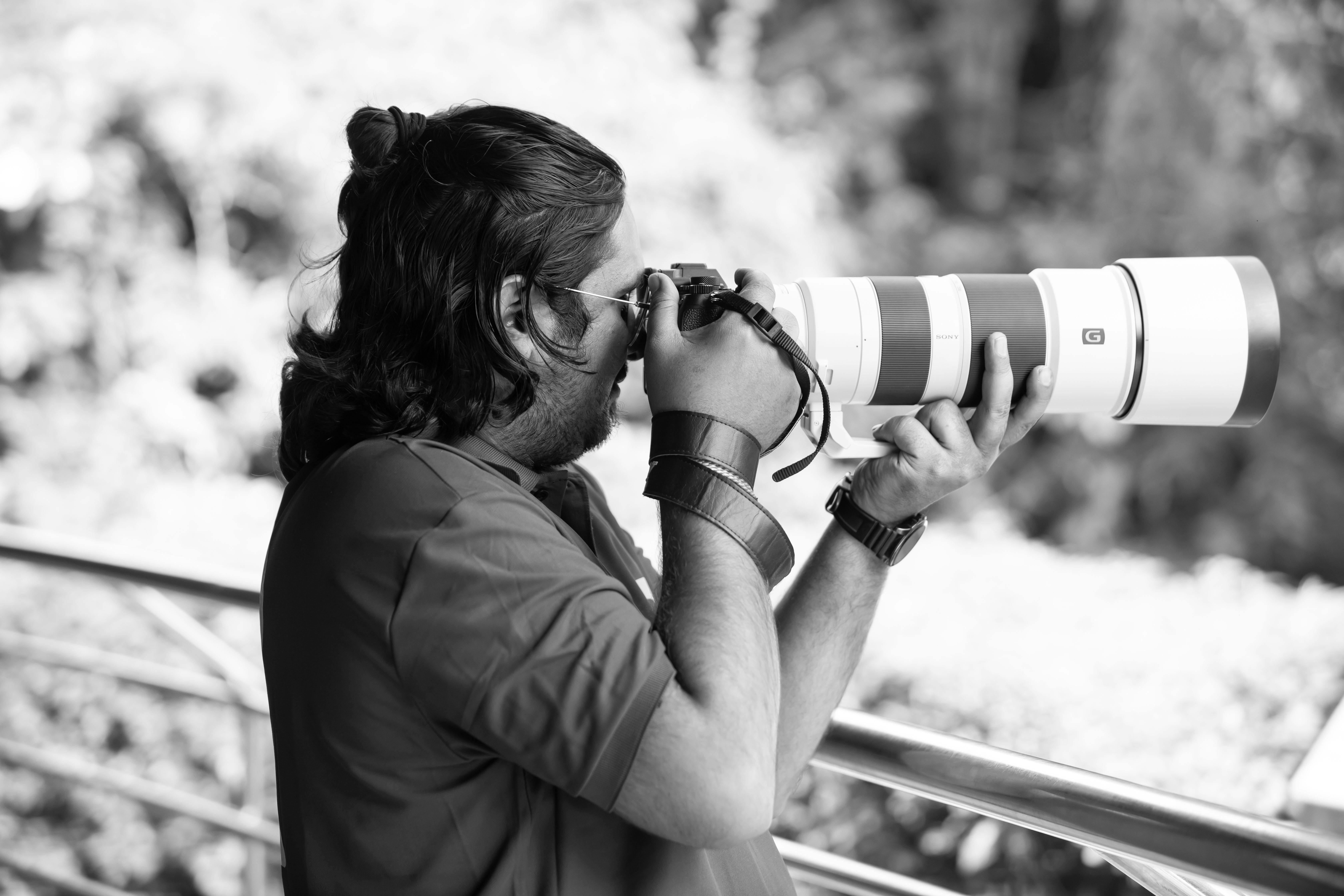 A photographer using a telephoto lens on a tripod to capture distant birds - bird photography tips and tricks