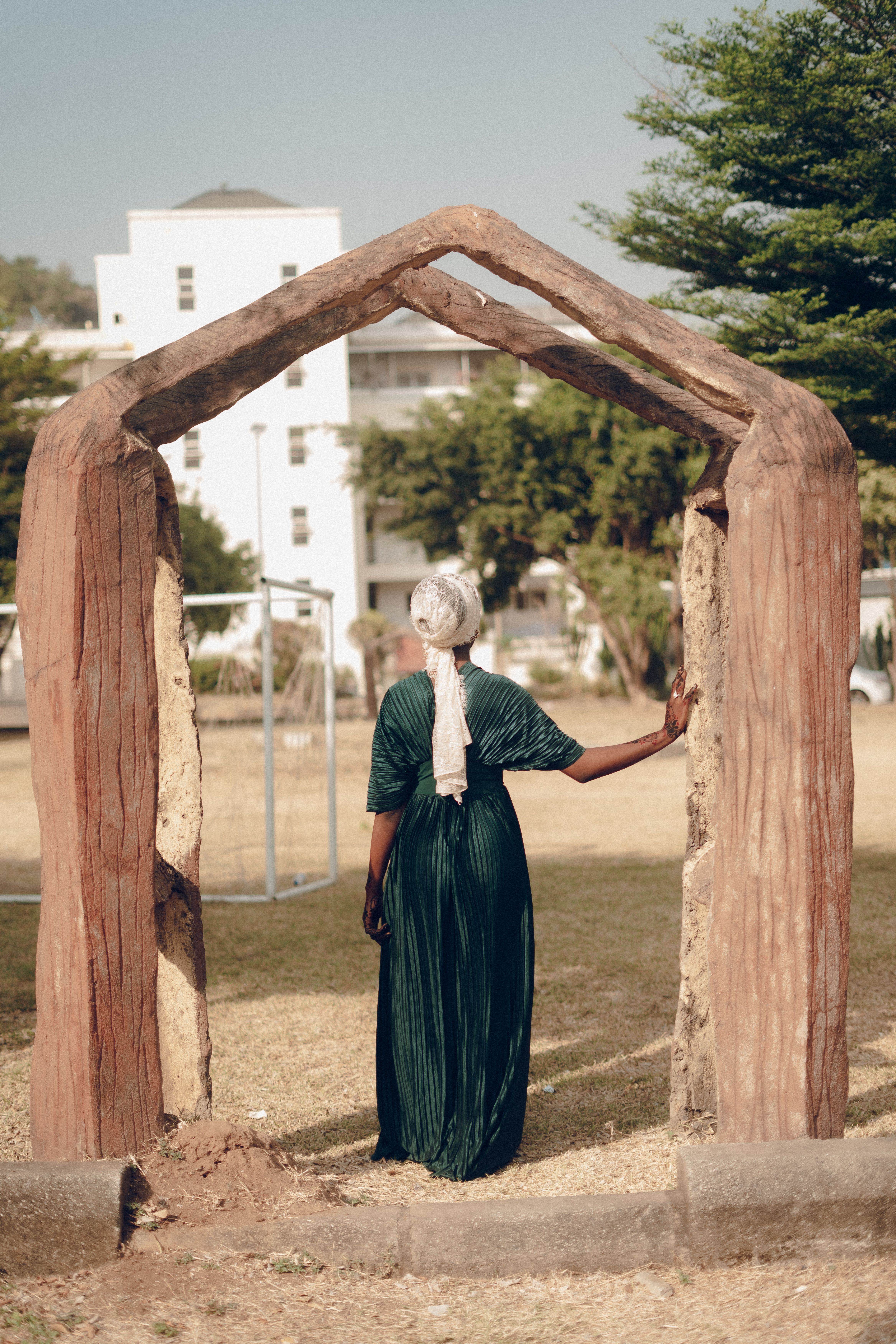 Elegant Woman in Traditional Dress by Wood Archway · Free Stock Photo