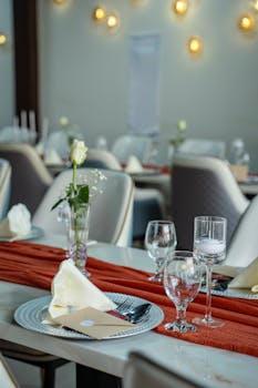 A beautifully arranged table setting in a Dubai restaurant, featuring glassware, cutlery, and floral decoration.