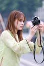 Young Woman in Traditional Dress Taking Photos in Hanoi