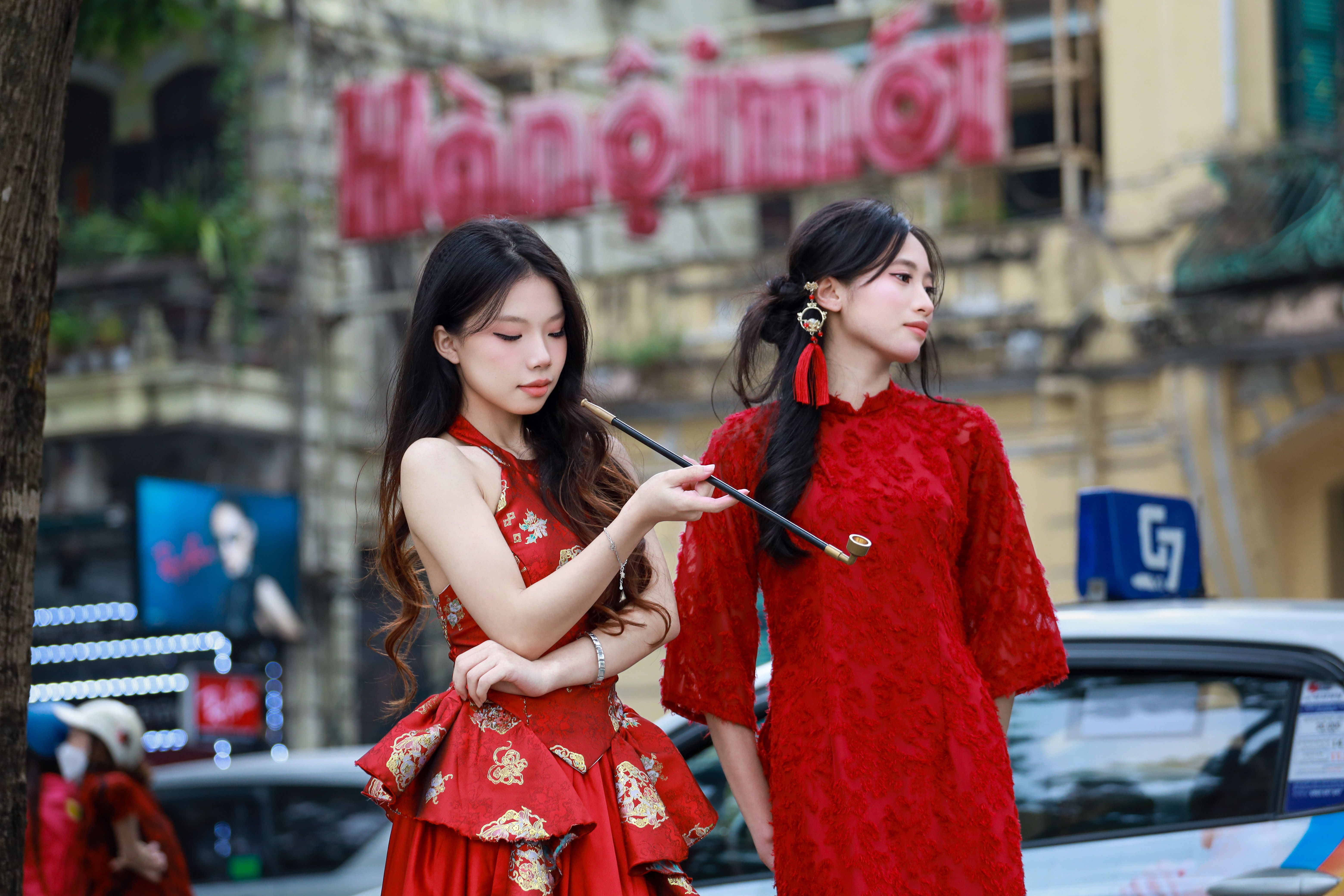 Fotomural Mujeres jóvenes con vestidos rojos mostrando la cultura vietnamita en Hà Nội.