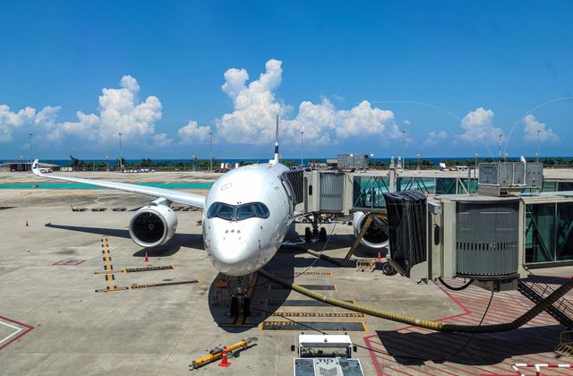 Jet plane at gate, Phuket International Airport, bright summer day. — arriving in Phuket