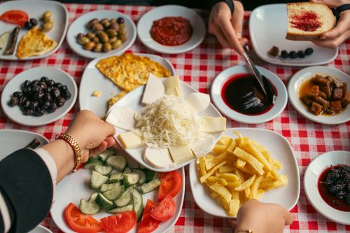 Free Delicious variety of cheeses, olives, and spreads on a checkered tablecloth, perfect for a gourmet breakfast. Stock Photo