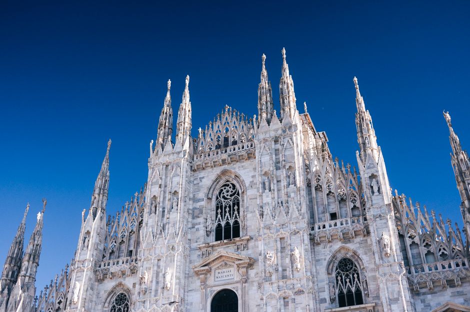 A breathtaking view of Milan Cathedral's Gothic architecture under a clear blue sky.